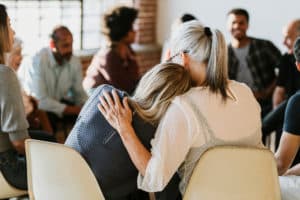Image of two women in a group counselling session leaning against each other. With support and guidance from an Edmonton group therapist you can build your supportive community with group therapy in Sherwood Park, AB.
