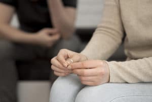 Image of a woman holding her wedding ring between her fingers. There are some common signs that suggest that a relationship could benefit from couples therapy in Sherwood Park, AB. If you identify with any of the signs in this blog a couple therapist in Sherwood Park, AB can help you work through them. Even if you don't see issues you can still benefit from marriage counselling in Edmonton. Call today to start!