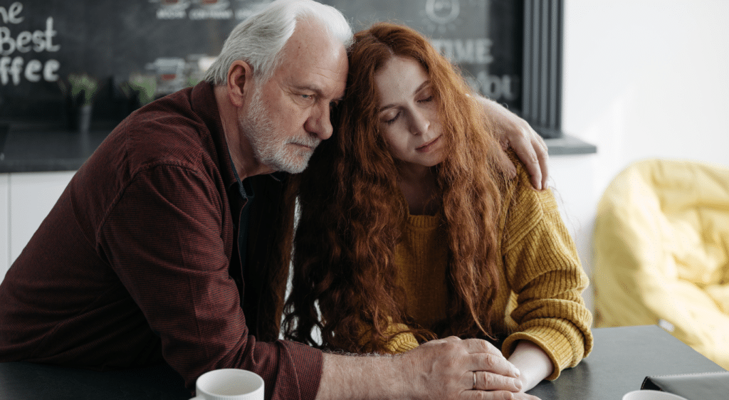 Image of a father and daughter looking sad while leaning against each other. Showing the need from support after loss from family, a grief counsellor, and grief groups. With grief counselling in Edmonton and Sherwood Park you dont have to go through it alone.