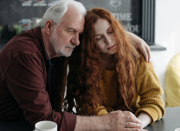 Image of a father and daughter looking sad while leaning against each other. Showing the need from support after loss from family, a grief counsellor, and grief groups. With grief counselling in Edmonton and Sherwood Park you dont have to go through it alone.