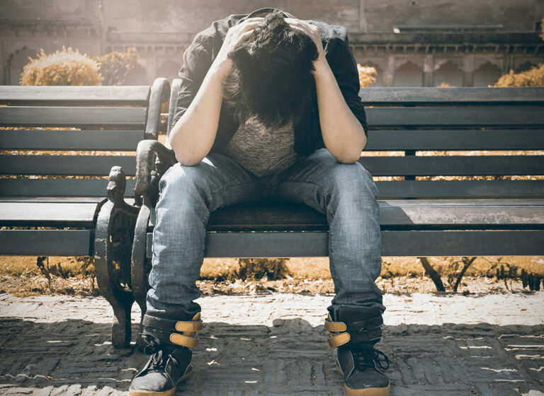 problematic man sitting on a bench